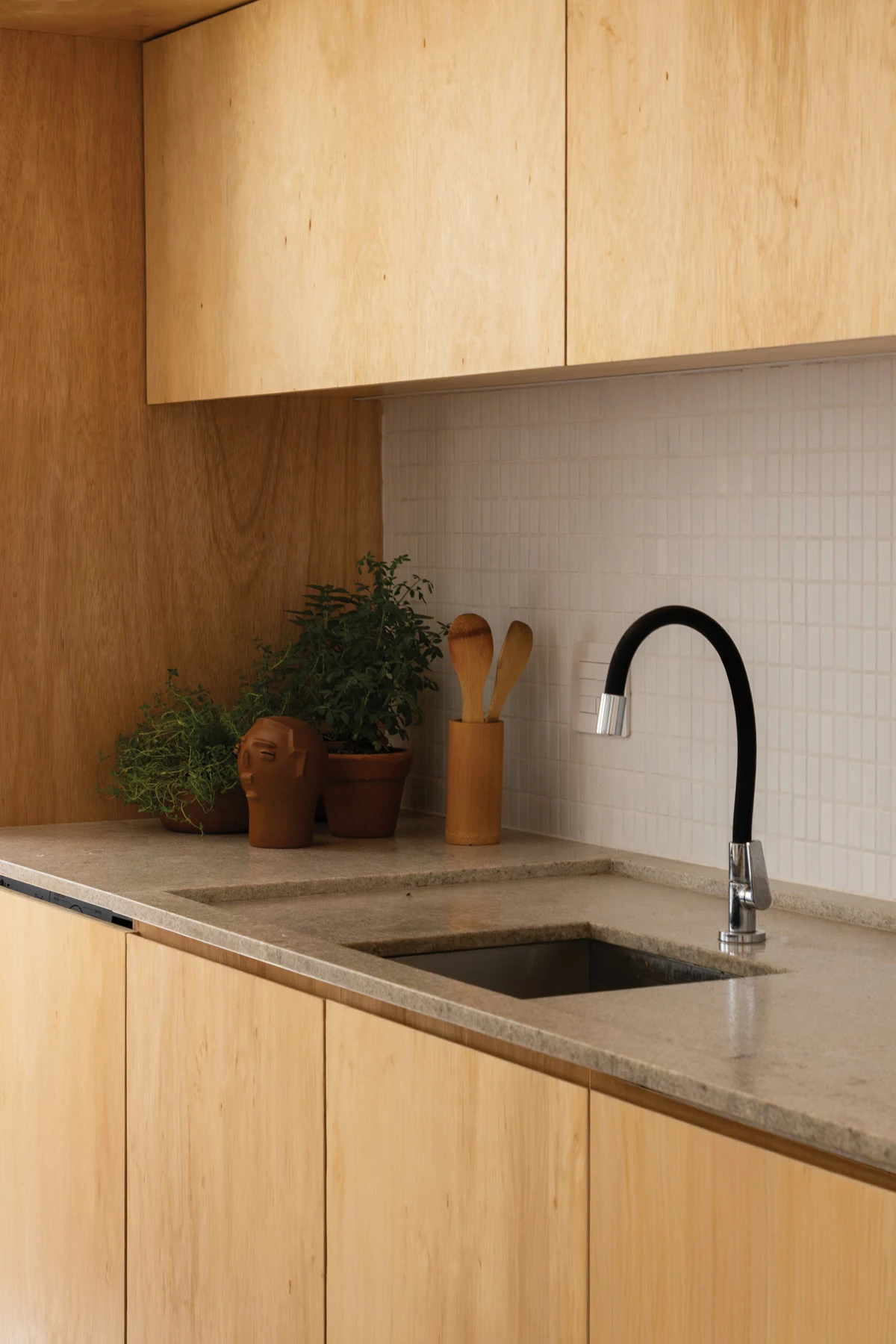 Timber kitchen cabinetry around a recessed sink and worktop