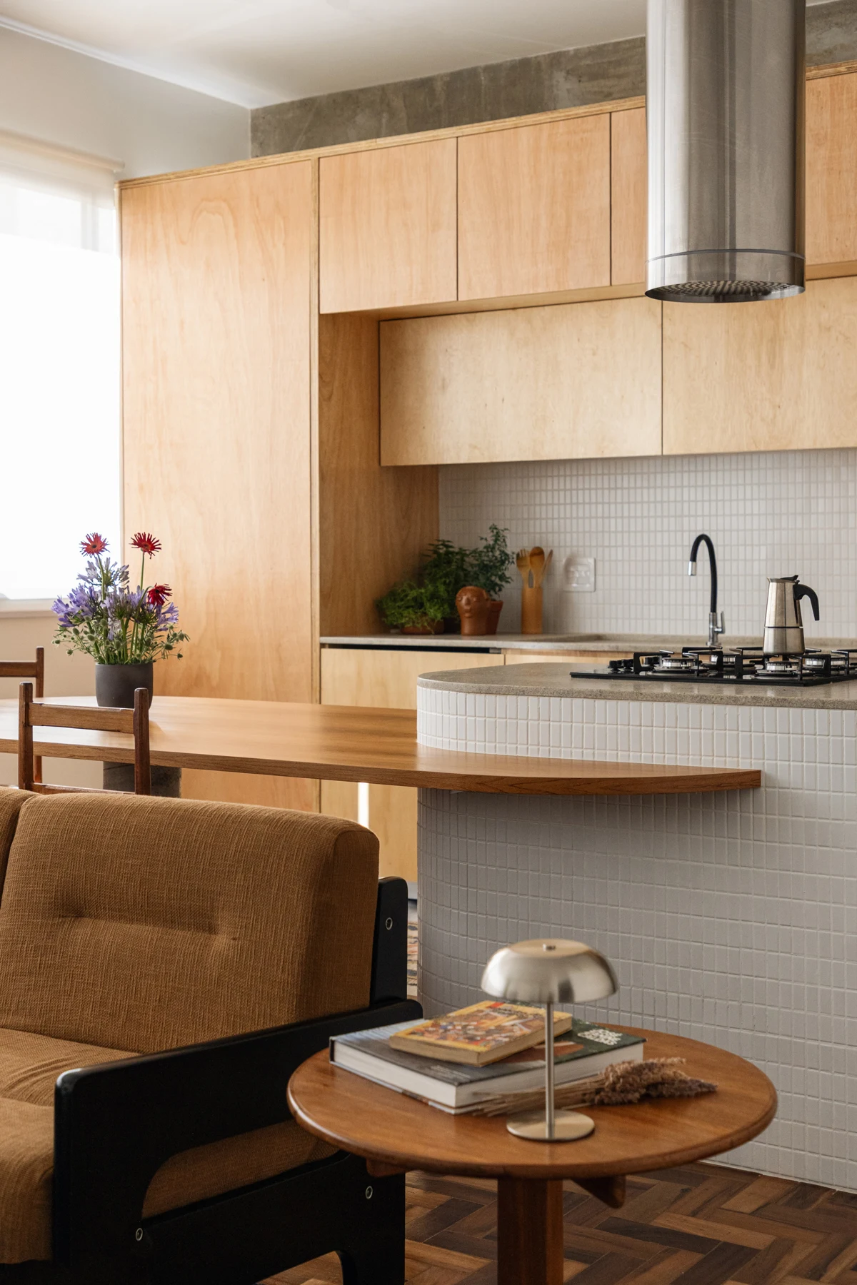 Rounded peninsula and dining surface seen from beside the sofa