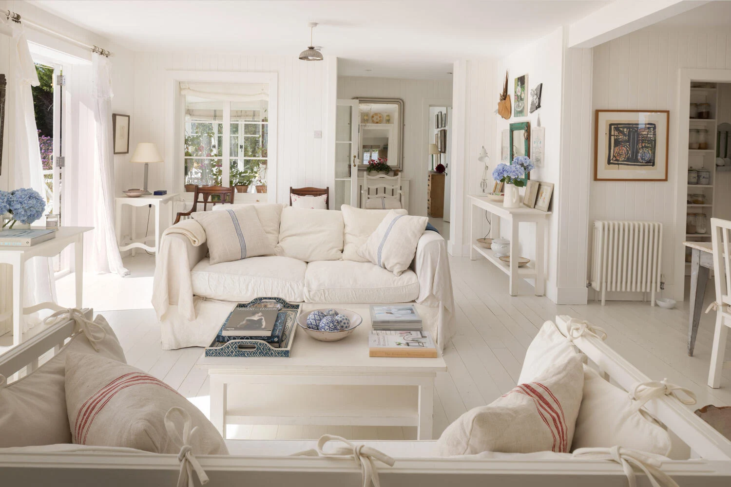 White living room opening towards the dining area