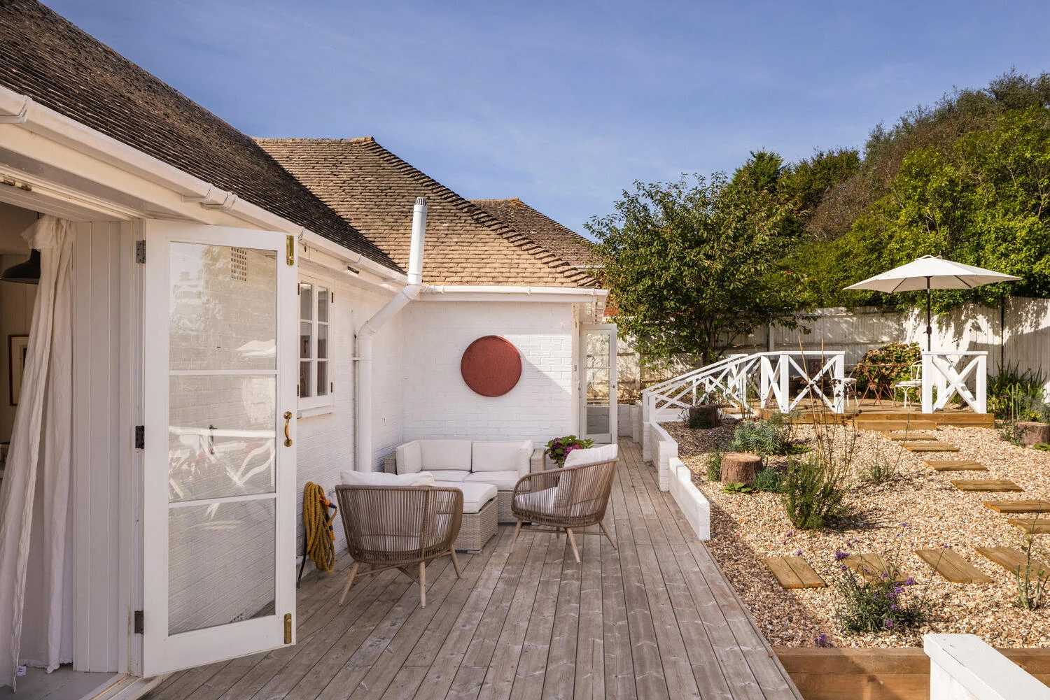 White exterior opening onto the timber terrace