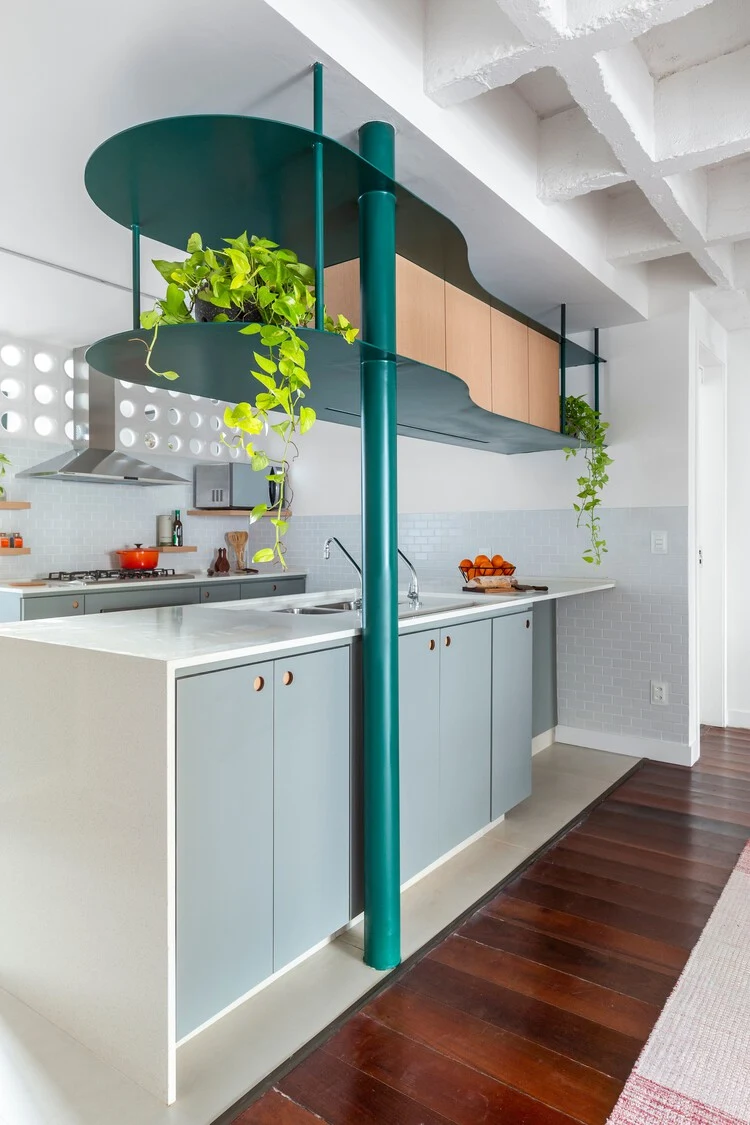 Angled view of suspended kitchen shelves with curved green metal edges, timber cupboards and open sides