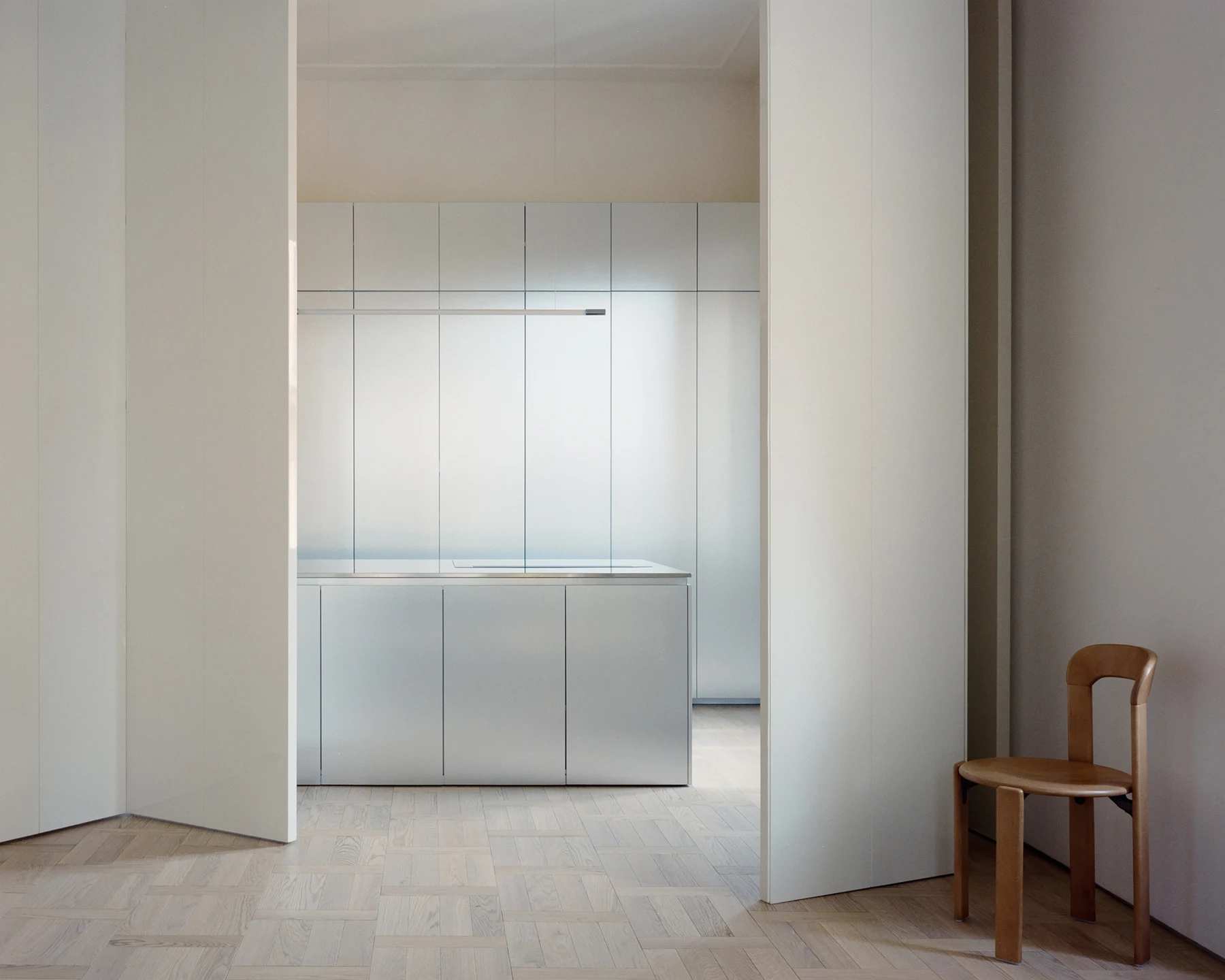 Metal kitchen viewed through tall folding room-divider panels