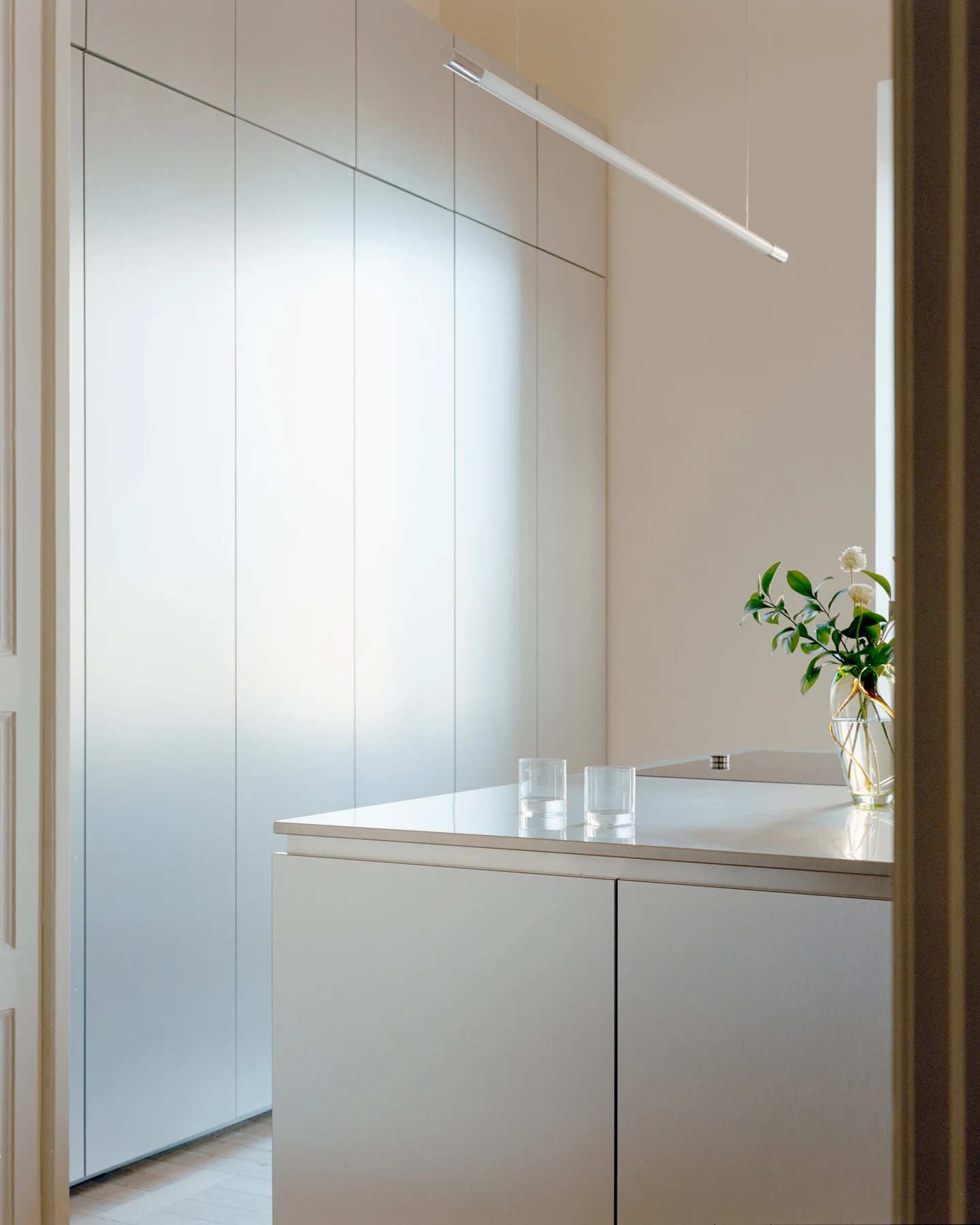 Side view of reflective kitchen island and full-height metal cabinetry
