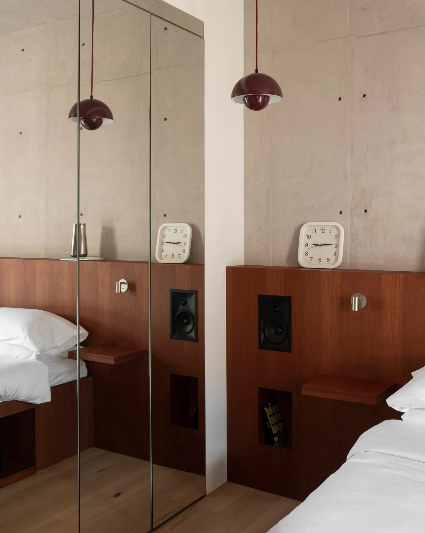Timber headboard with integrated speakers, bedside storage and burgundy pendant lighting