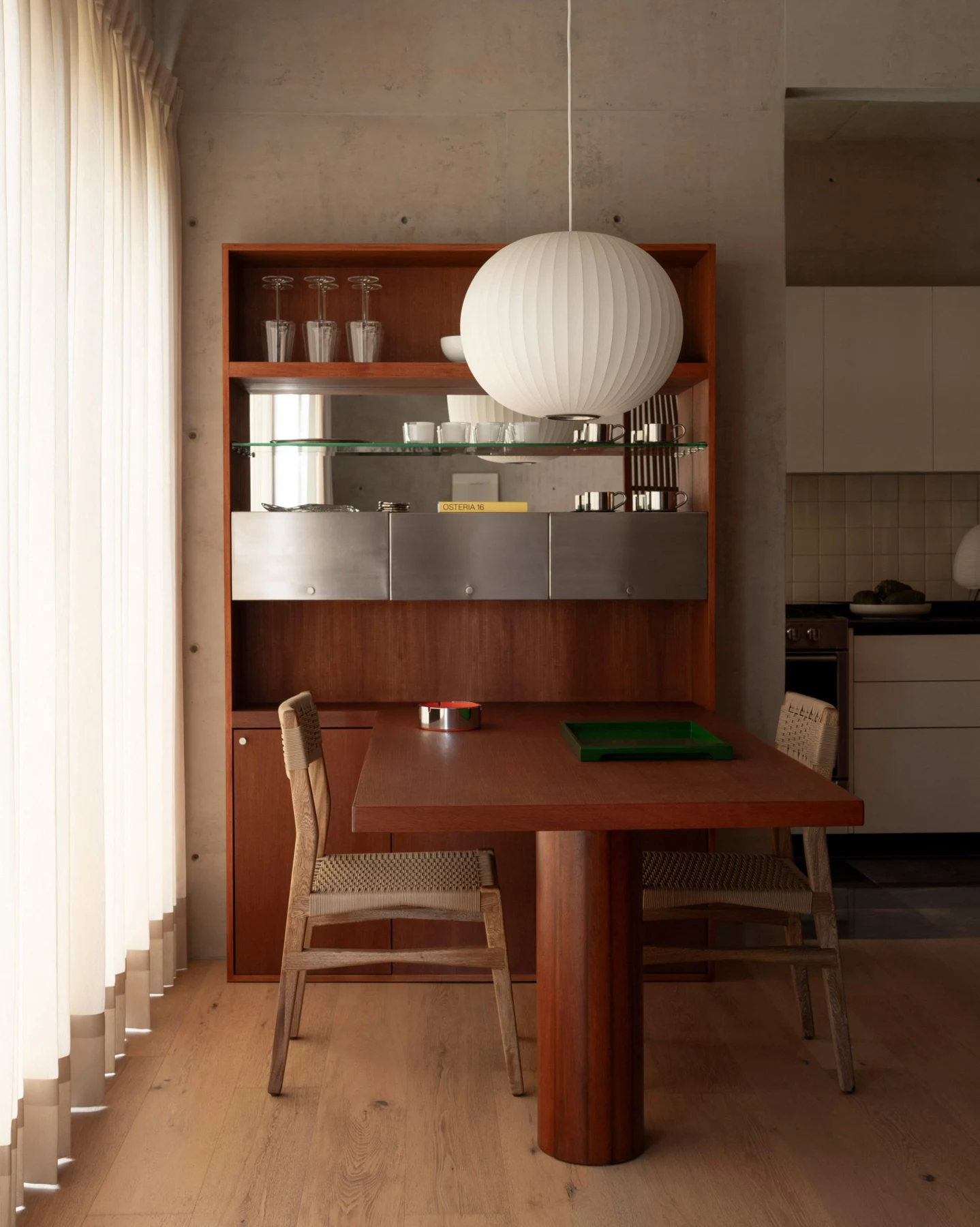 Wood table extending from shelving with metal-fronted storage and oak floorboards below